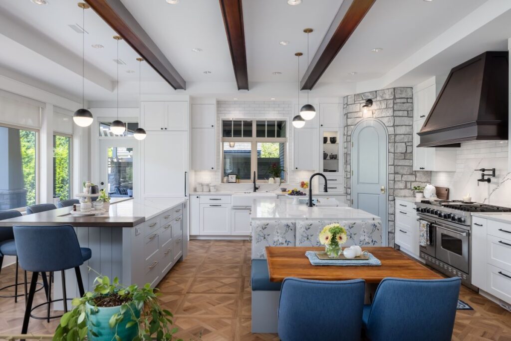 Side view of a beautifully renovated kitchen featuring dual islands, sleek cabinetry, and elegant finishes, designed for functionality and seamless connection to the greatroom.
