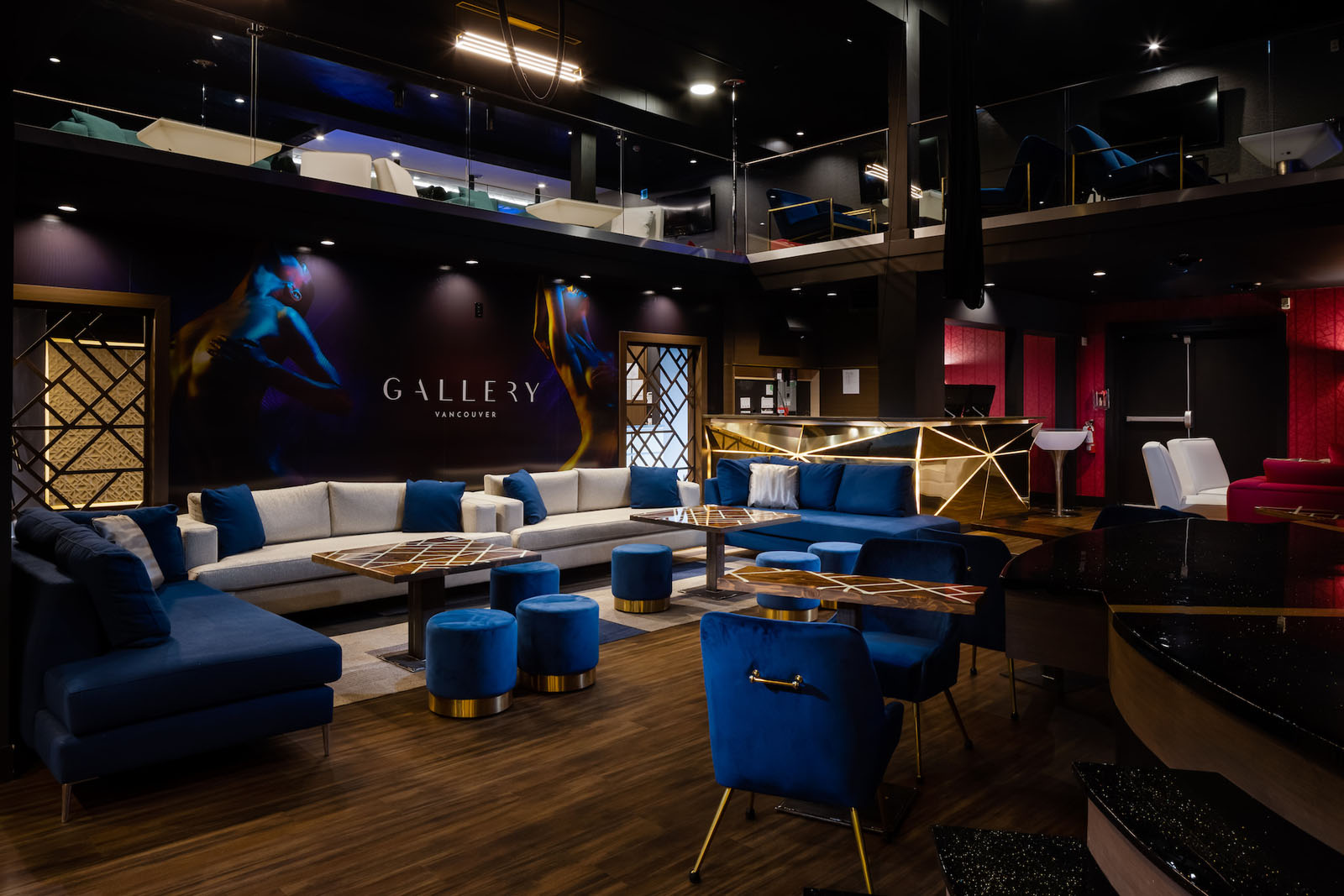 A stylish nightclub featuring electric blue chairs and stools, sleek couch-style banquette seating, and moody lighting that sets the perfect ambiance for an intimate and lively experience.