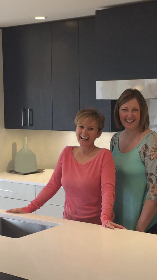 Cindy and Sarah smiling from behind the new quartz kitchen island.