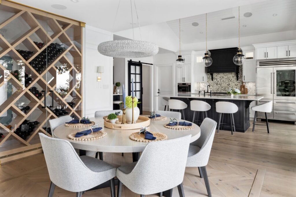 Elegant round dining table with curved chairs, set in an open-concept space with a stylish kitchen and island in the background, designed for connected and comfortable entertaining.